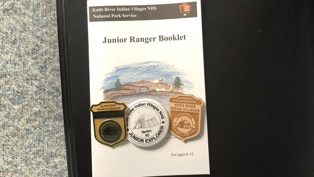 Jr Ranger booklet with three badges on it.