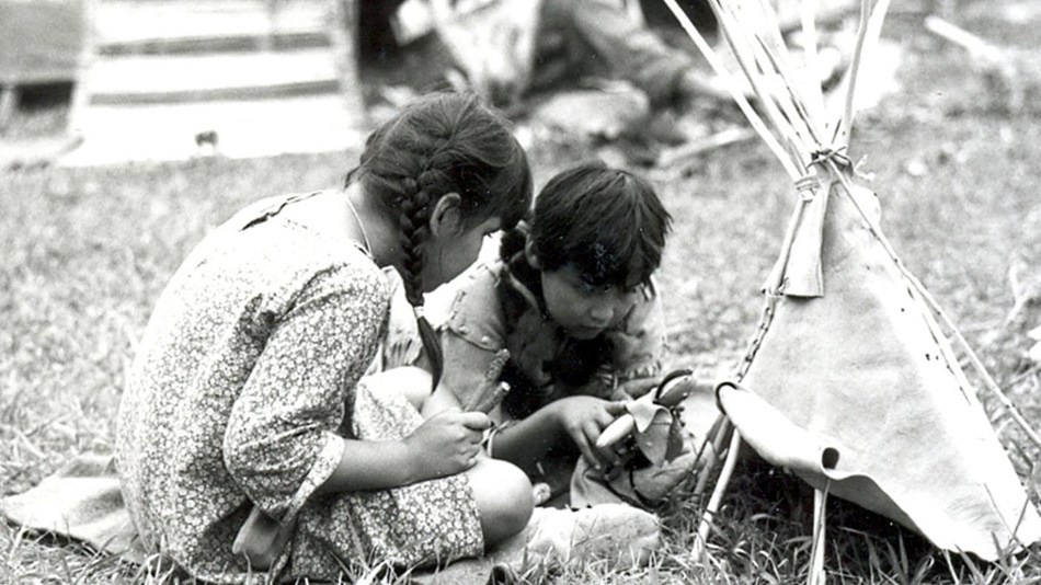 Two children re-enacting village life