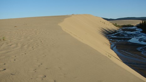 sand dunes with creek on right side