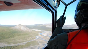 pilot looking out at a river with plane wing in the corner