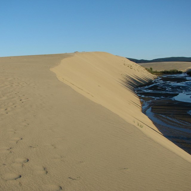 sand dunes with creek on right side