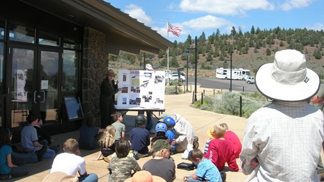 A ranger giving a presentation to a group of school kids.