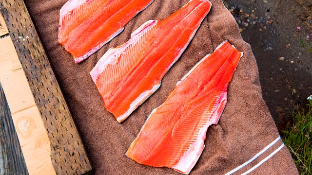 Fish fillets sit on a wooden board