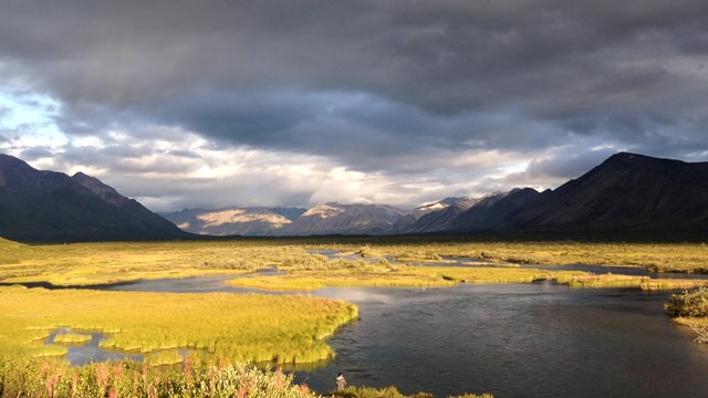 River at sunset with mountains in background.