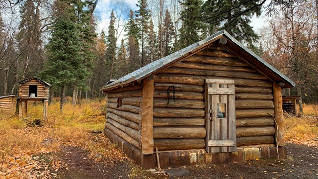 log cabin in the woods in the fall