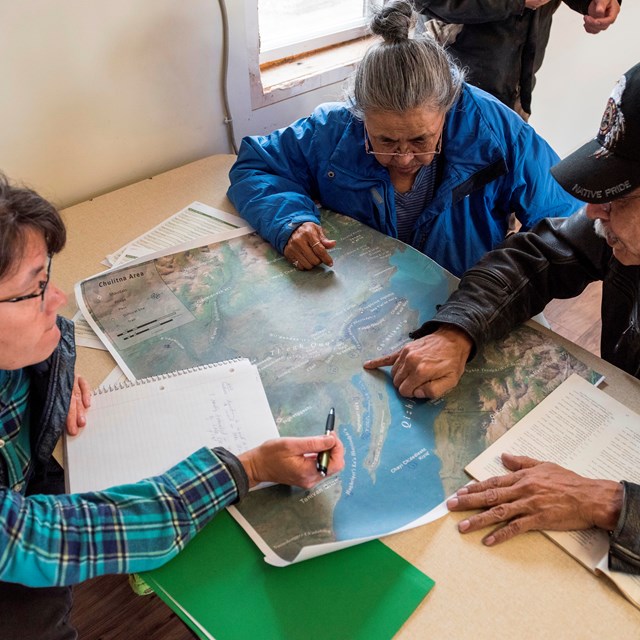 three people around a map