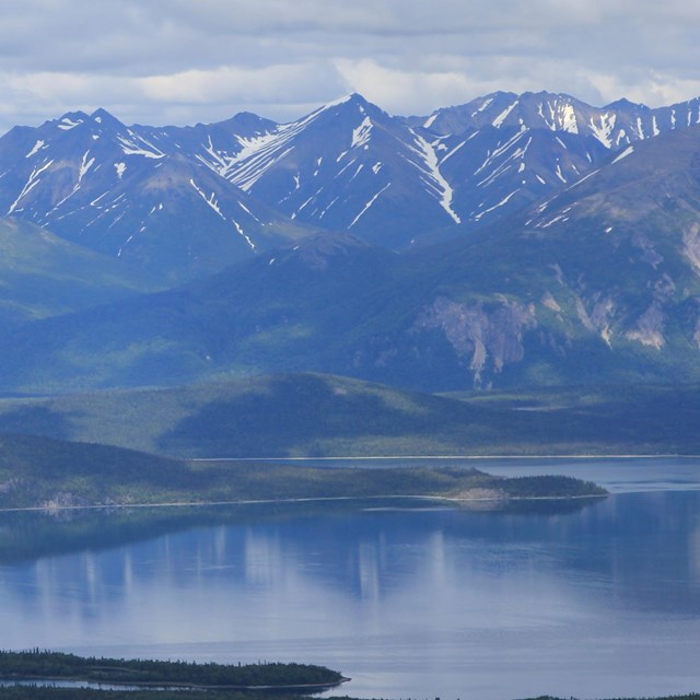 mountains reflect in Lake Clark's wateer