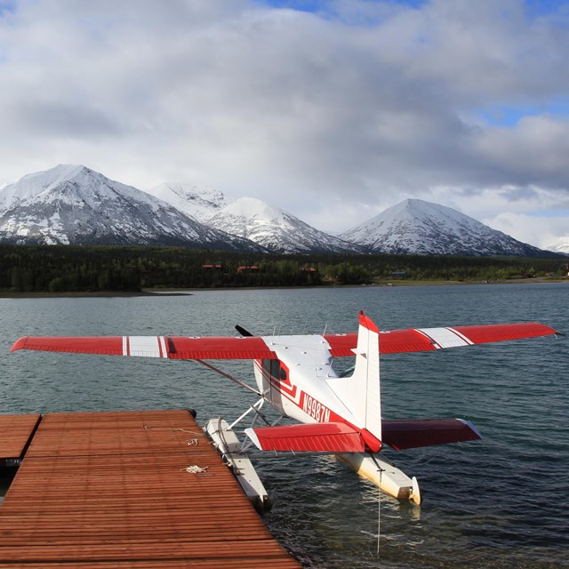 A floatplane parked at a dock in Port Alsworth