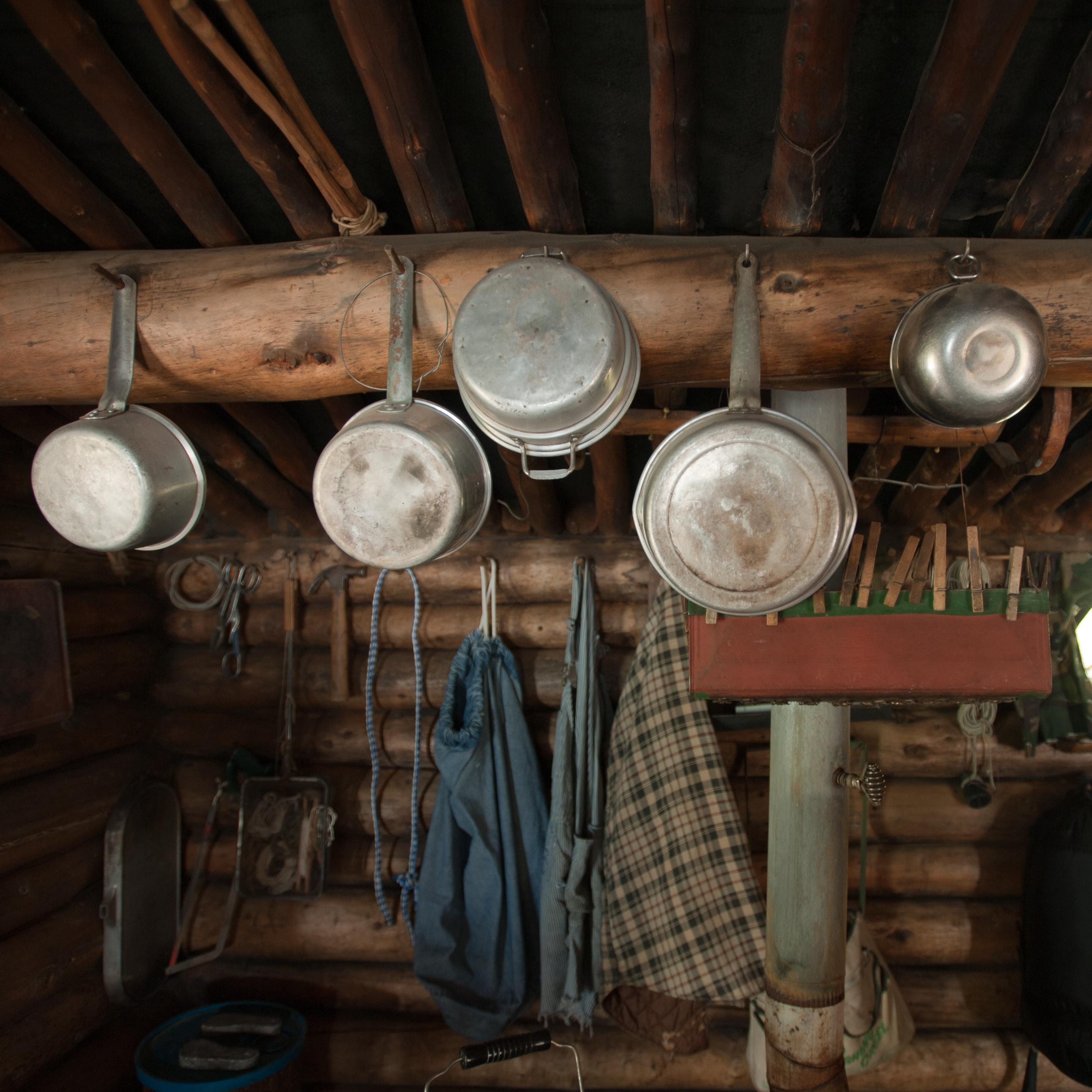 Pots and pans hang from a cabin wall