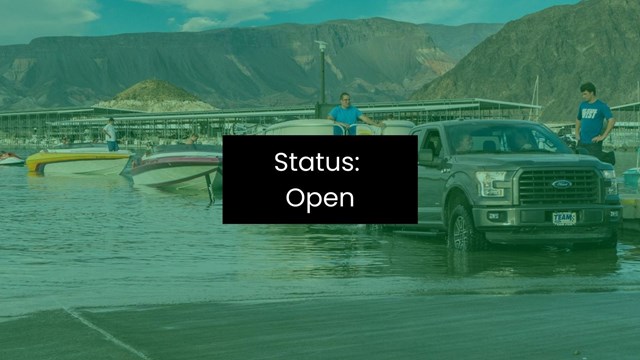 A truck launches a boat into a large, enclosed body of water.