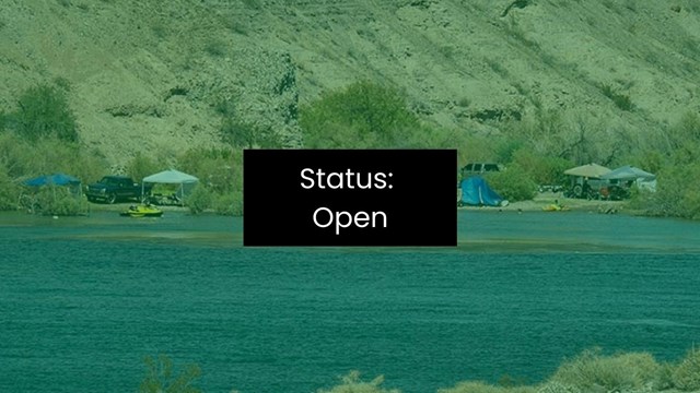 People recreate on a beach overlooking an enclosed body of water.