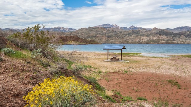 a picnic table next to a body of water