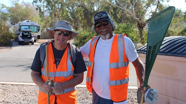 Two volunteers posing for photo after collecting trash.