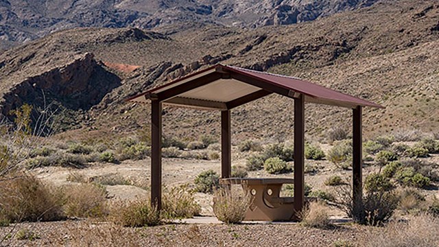A picnic shelter with a mountainous landscape in the background