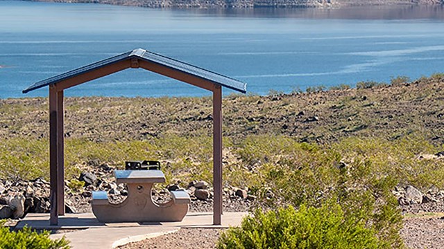 A picnic shelter overlooking a large body of water.