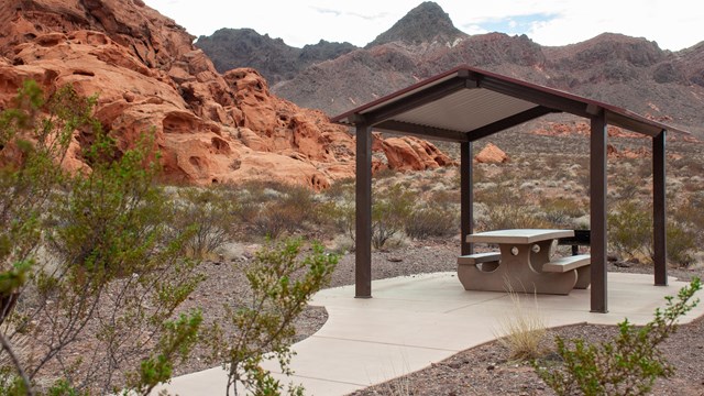 A picnic shelter surrounded by red rocks. 