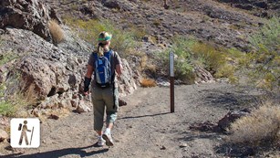 A hiker walks down a trail