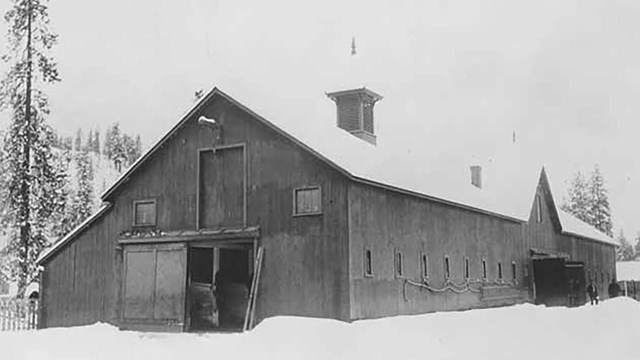 A historic black and white photo of the barn at Fort Spokane is shown.