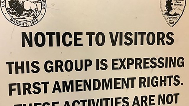 A close up view of permitted area signs for First Amendment gatherings.