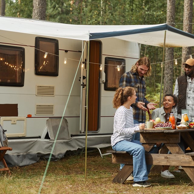 An RV with a group of people enjoying their camping experience.