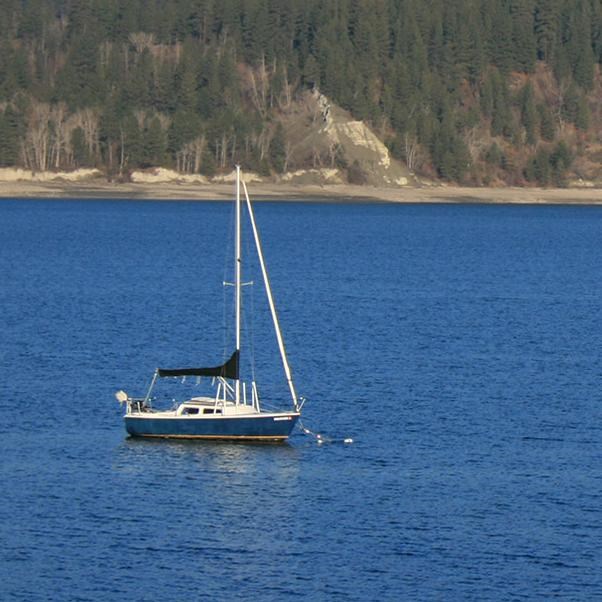 A sailboat on the lake with mountains in the background