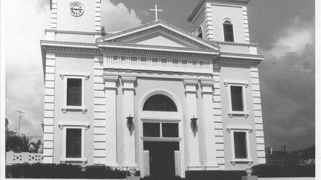 Church building with two towers in between a triangle roof with a cross on it, black and white