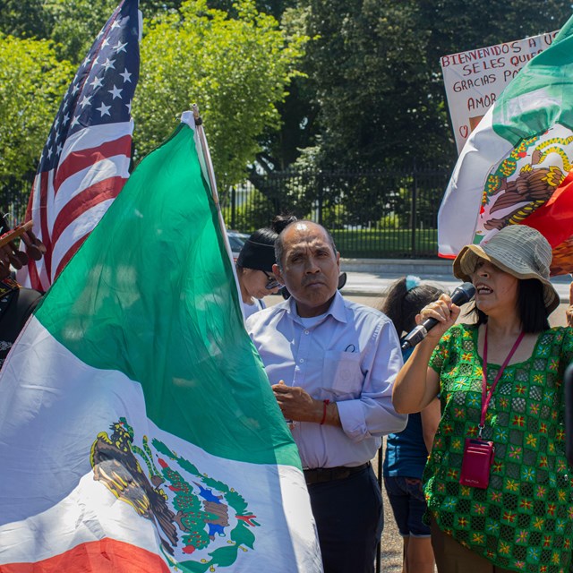 Musicians performing next to US and Mexican flags 