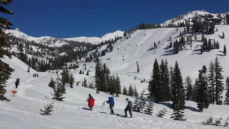 People on a snow-covered route in a mountain landscape