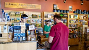 A man pays for items at a small store.