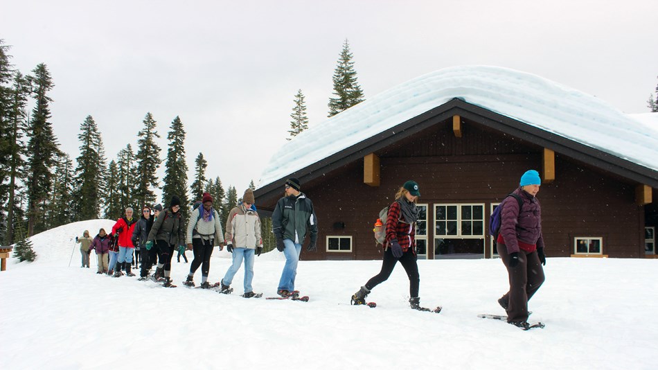 Visitors snowshoe outside the Kohm Yah-mah-nee Visitor Center