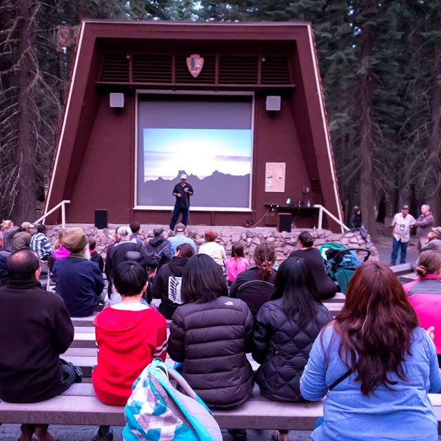 Visitors at an evening program at an amphitheater.