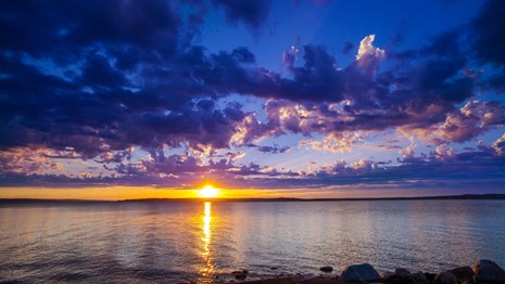 Bright setting sun between Lake Sakakawea and the clouds. Photo by Scott Mestrezat