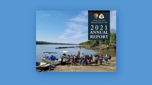 2021 Annual Report. Park Service Logo. Lewis and Clark Trial logo. photo of group on a riverbank. 