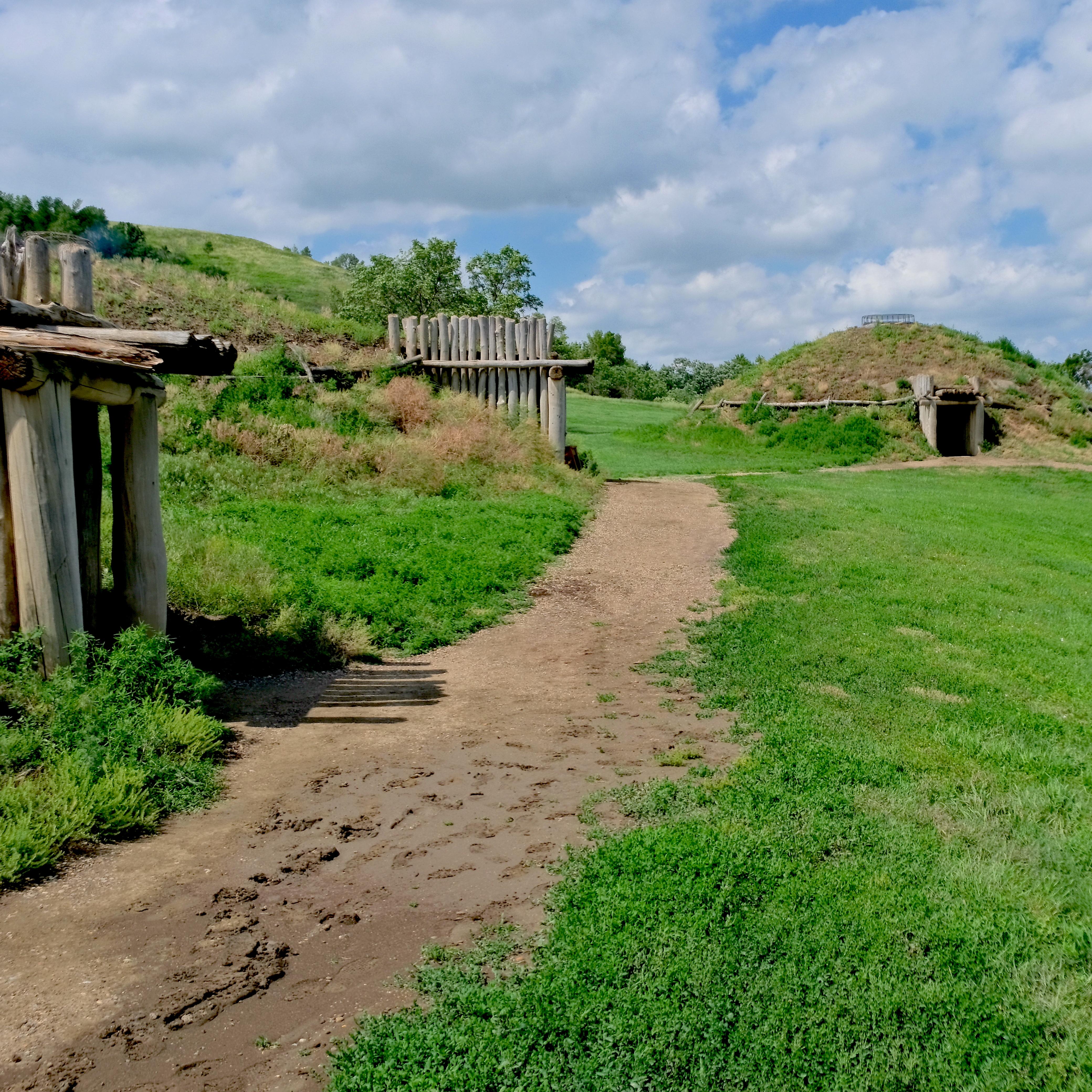 earth lodge village in a green prairie 