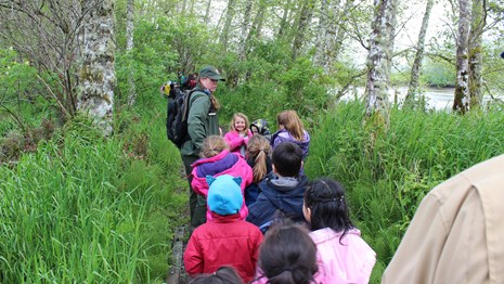 Ranger leading a plant walk to kids and parents
