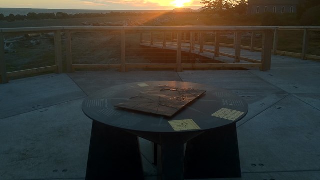 Exhibit at Middle Village with a sunset in the background