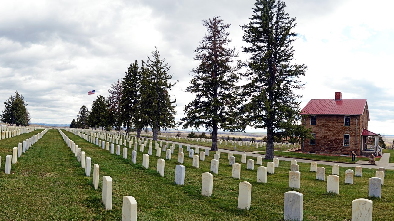 Custer National Cemetery markers with the Stonehouse to the right.