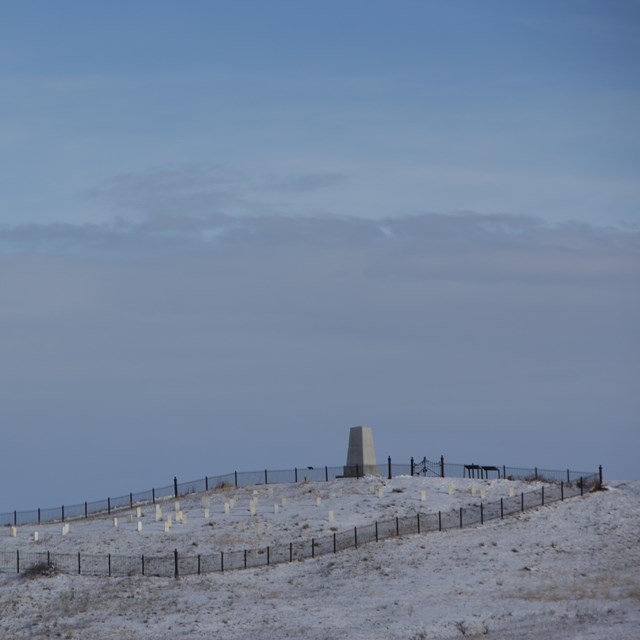 Hillside with monument and headstones in winter