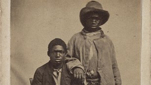 Photo of two runaway African American slaves in worn, shabby clothing
