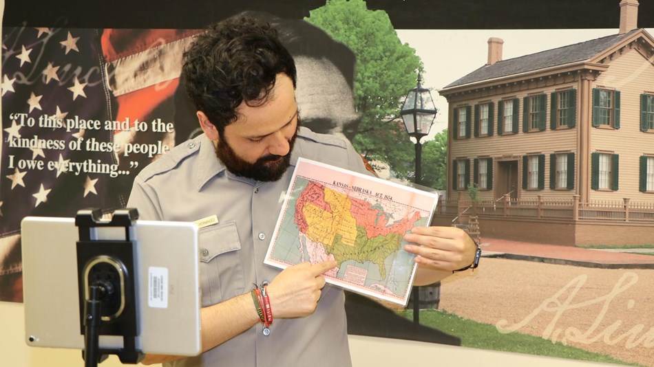 Ranger standing in front of a tablet showing students a 1854 United States map