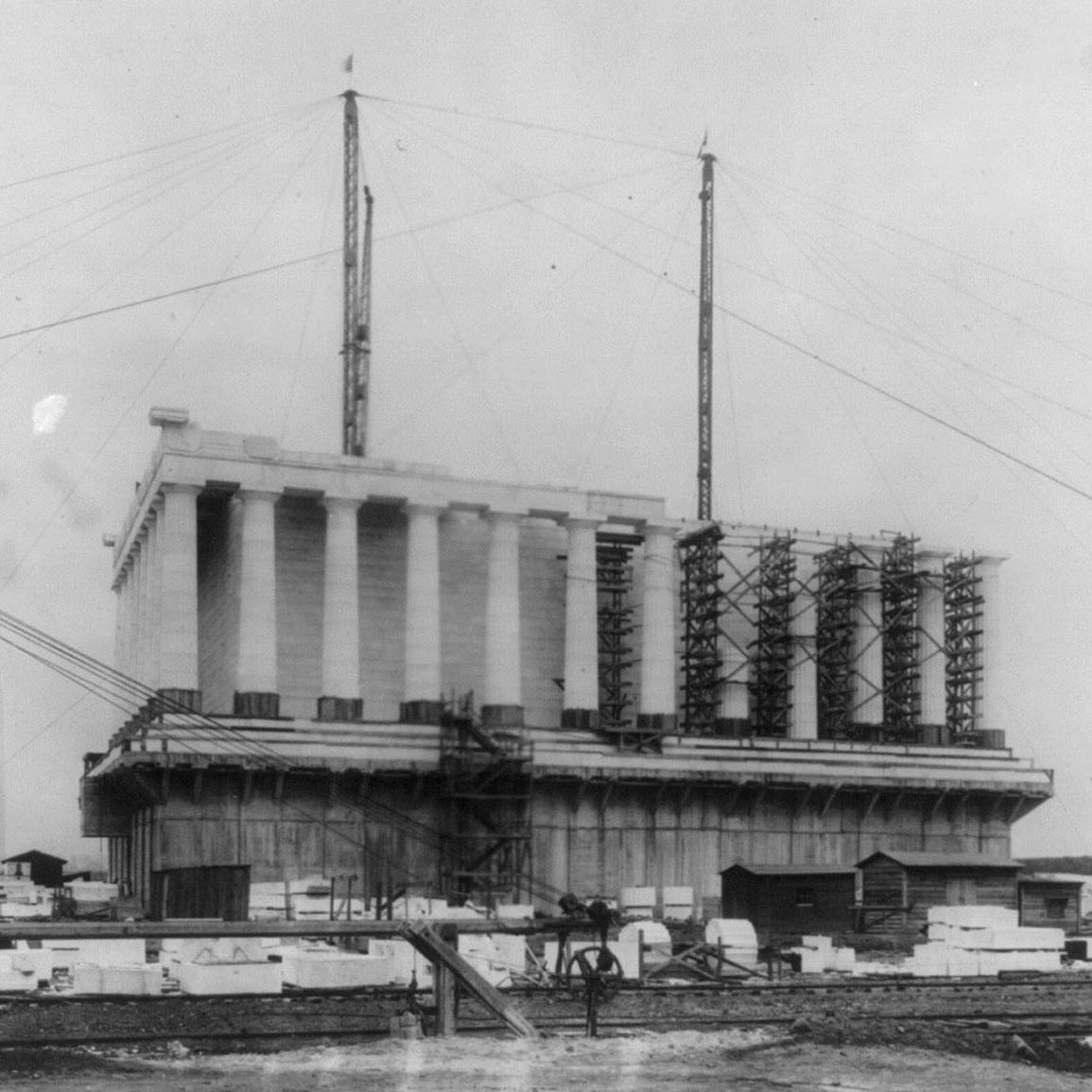 A partially built Lincoln Memorial shows an exposed lower level and cranes.