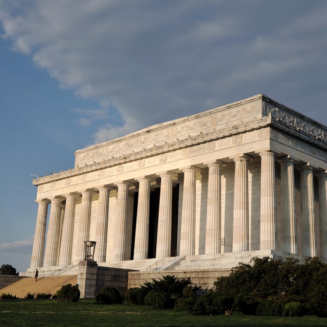 The front of the Lincoln Memorial, a large rectangular white marble building surrounded by columns.