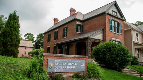 Two story brick house with a sign for Paul Lawrence Dunbar House 