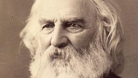 Bust-length portrait of Henry Longfellow with white hair and beard