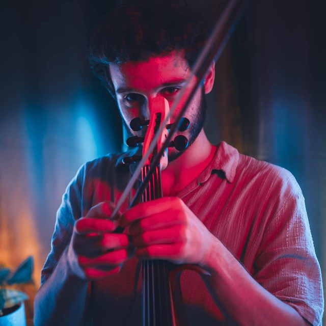 Man holding violin in front of face