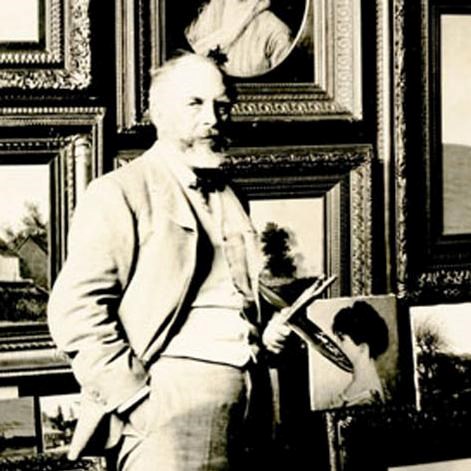 Man standing in front of wall covered in framed artwork