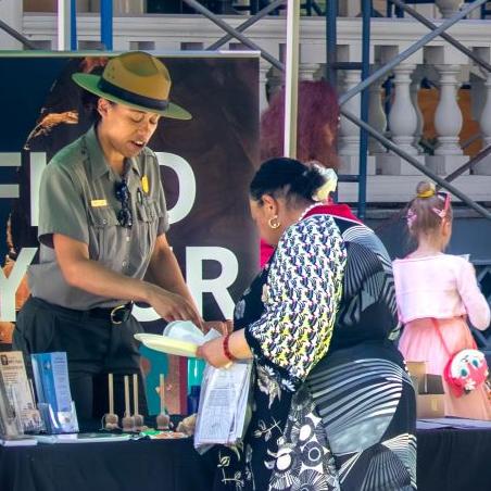 Park ranger talking to a visitor at an outdoor tent