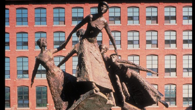 A statue of five women leaning and pulling on eachother