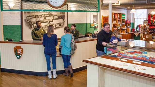 Visitors buy museum tickets at an entrance desk