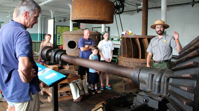 A park ranger explains a complex industrial machine